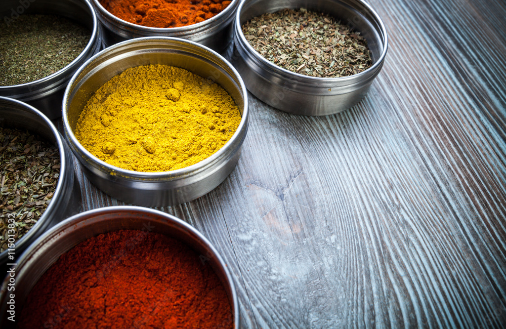 Spices and herbs in metal containers on wooden table Spices and herbs in metal containers on wooden table