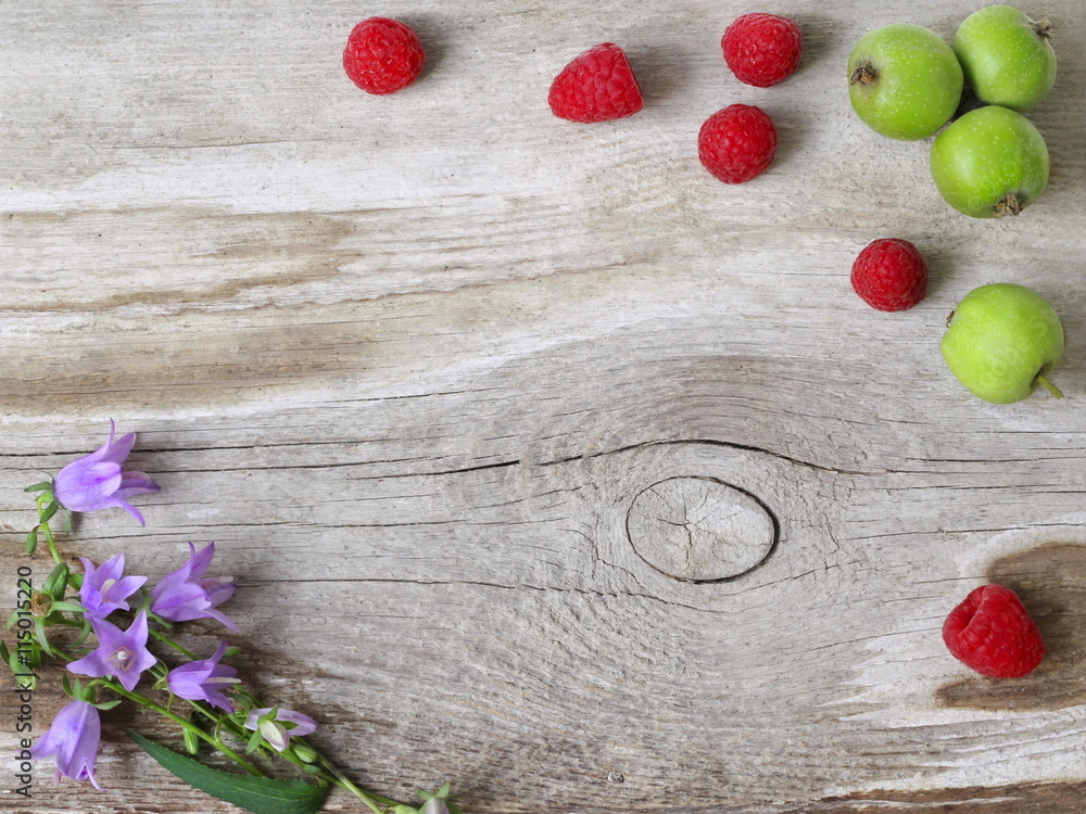 Φωτογραφία Natural background, frame or border with red raspberries, green apples and purple flowers on a wooden plank