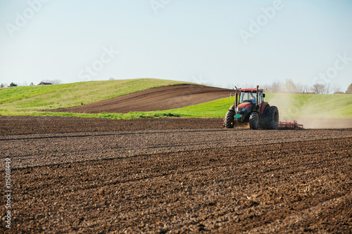 Tractor cultivating field at spring