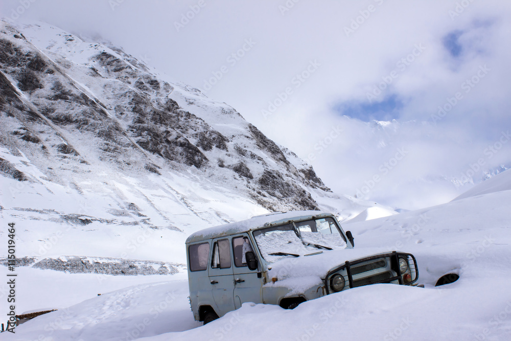 Old russian jeep buried in deep snow in the mountains