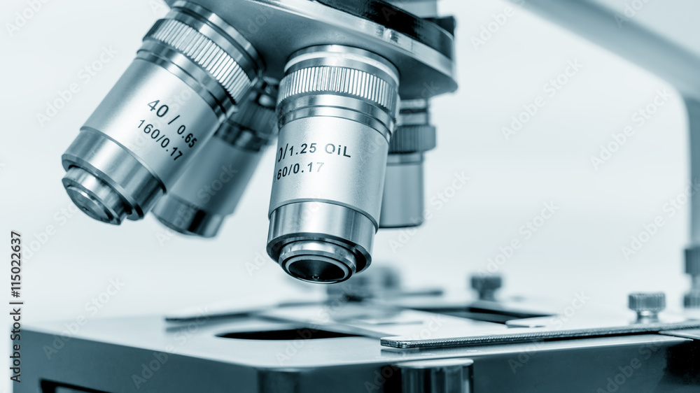 Microscope and test tubes in laboratory, Blue toned image Microscope and test tubes in laboratory, Blue toned image