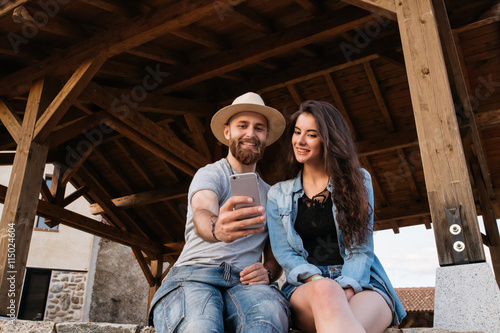 Couple of a boy and a young woman taking a selfie and smiling wi