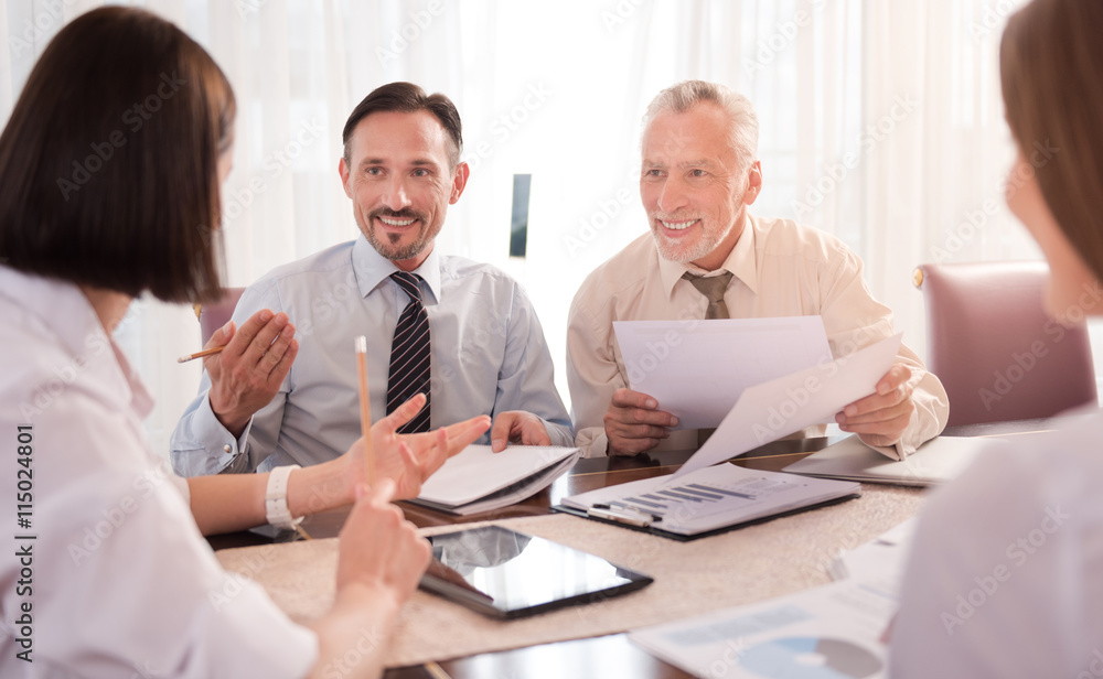 Positive smiling colleagues discussing project Positive smiling colleagues discussing project
