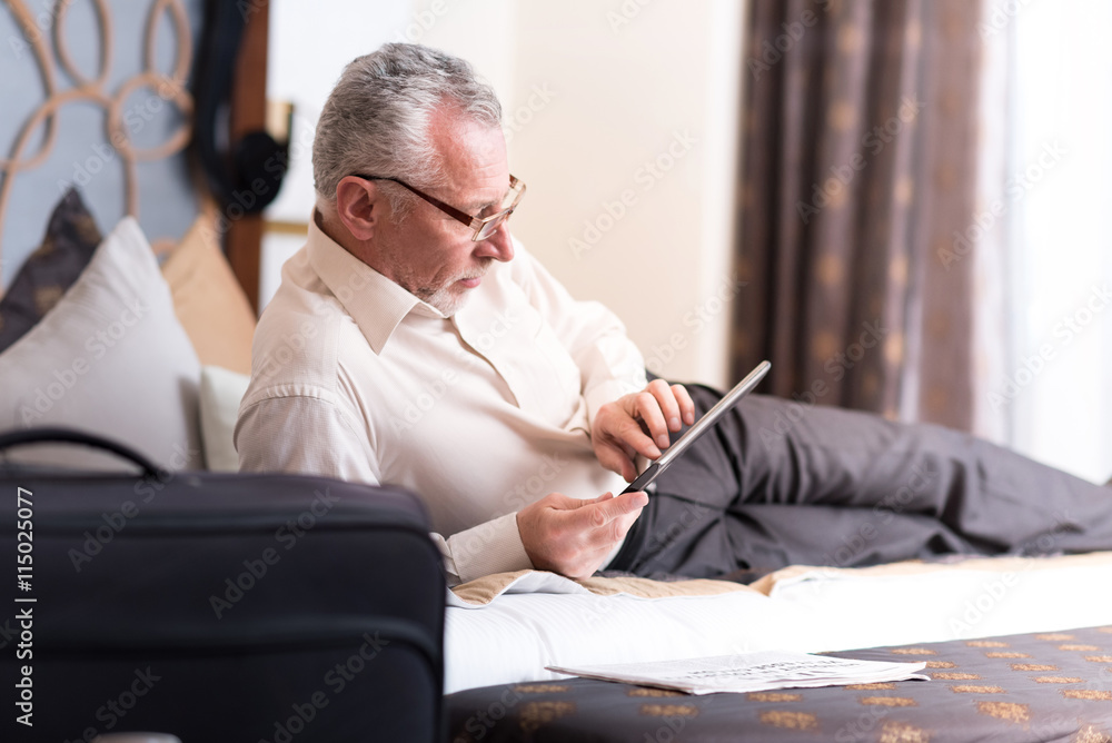 Fototapeta premium Positive delighted man sitting on the bed