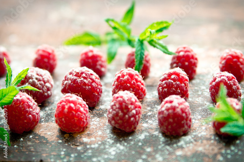 Ripe sweet raspberries on wooden background