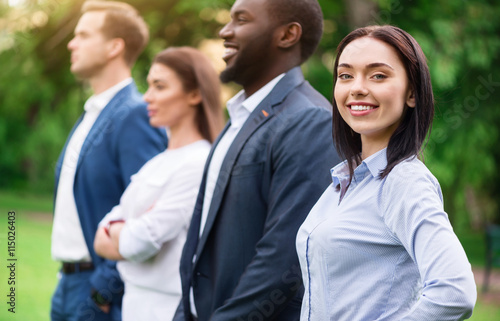 Positive colleagues standing outside © zinkevych