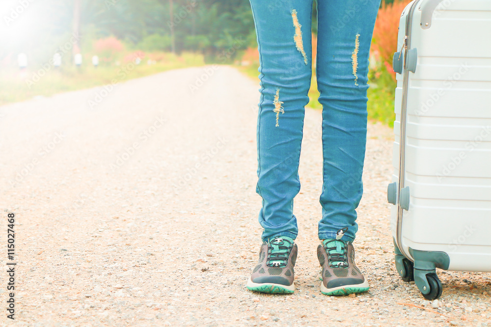 woman traveler with bag walking on the road to the mountain.