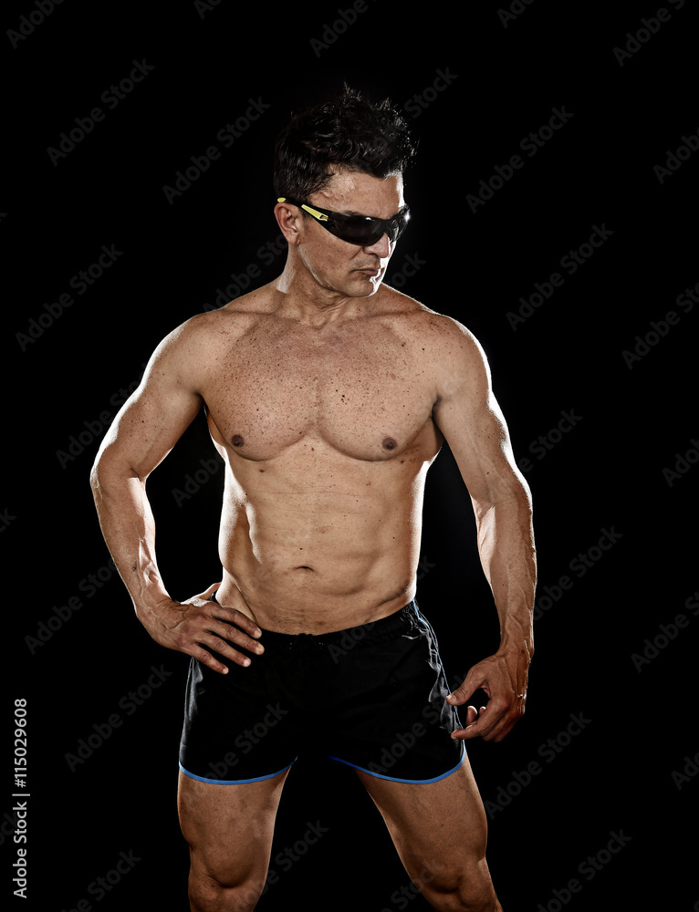 Fototapeta premium attractive sport man with fit strong bodybuilder body posing cool in corporate gym portrait with sunglasses