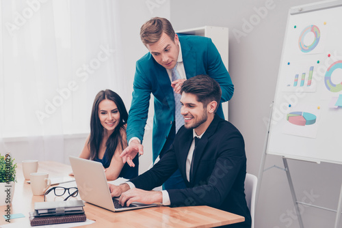 Young businessman showing financial plan on laptop to his collea photo