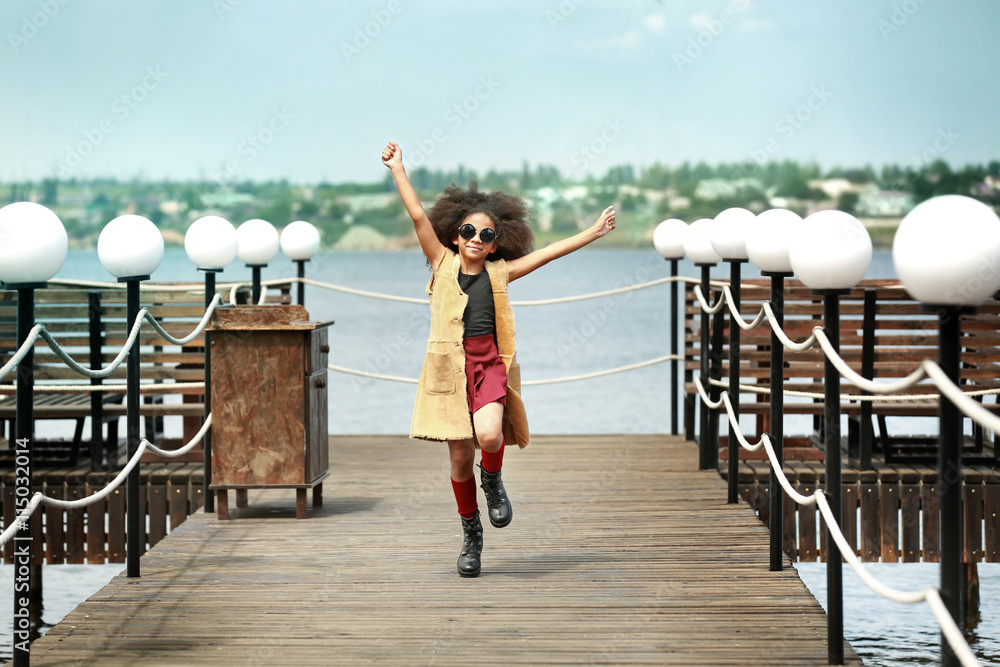 Afro American  little girl wearing stylish clothes outdoors. Fashion kid concept