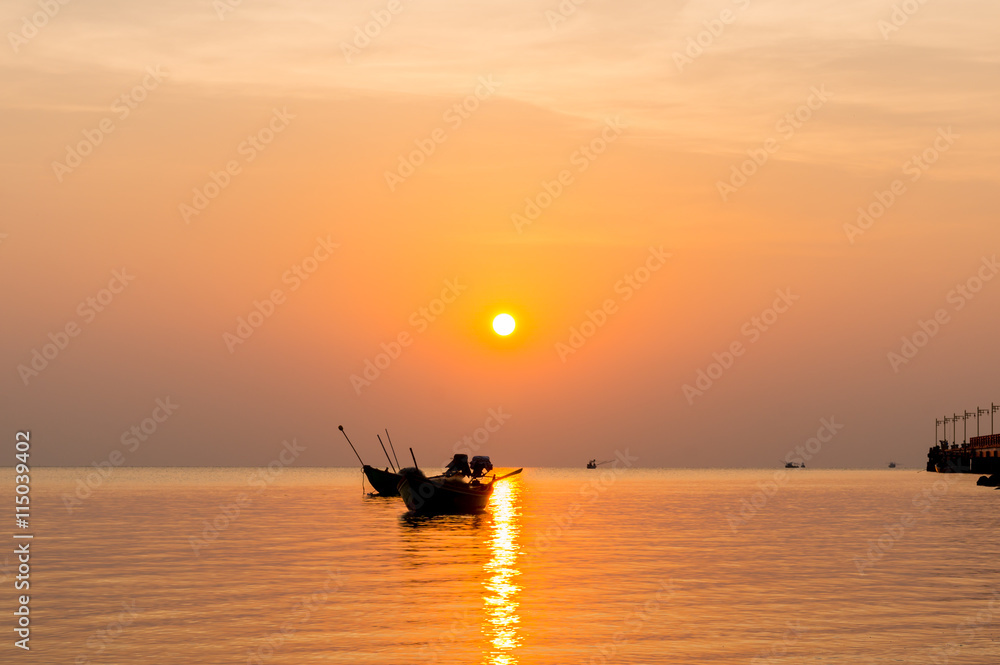 Fototapeta premium silhouette of Small fishing boats on the sea during sunrise