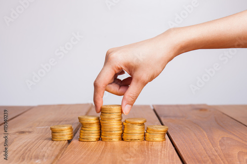 Savings, female hand stacking gold coins