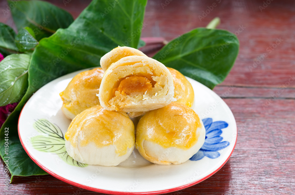 A small sweet chinese pantry cake on plate with green leaf A small sweet chinese pantry cake on plate with green leaf