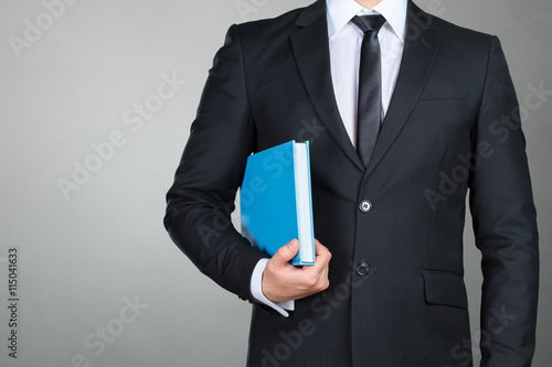 Unrecognizable businessman holding a book closeup photo