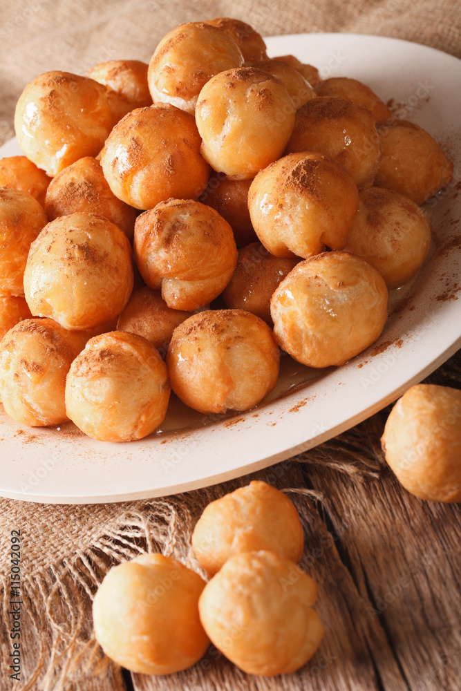 Greek loukoumades donuts with honey and cinnamon closeup. vertical
Greek loukoumades donuts with honey and cinnamon closeup. vertical