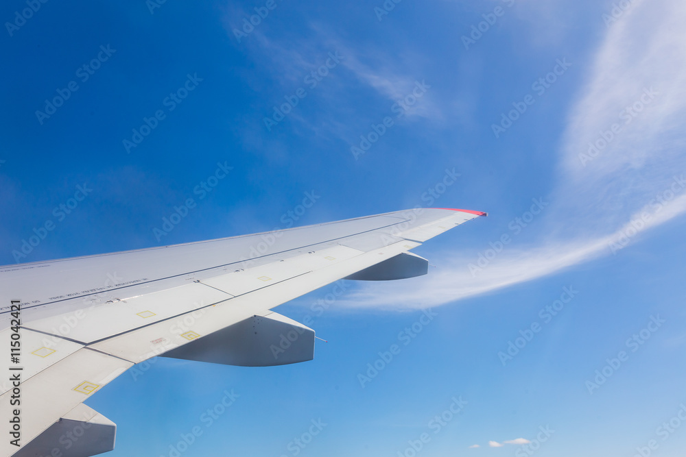Fototapeta premium View from airplane window with blue sky and white clouds