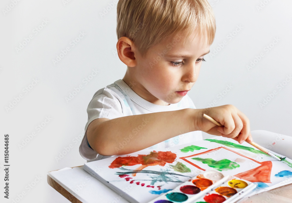 Happy cheerful child draws paints a southpaw in the album, using Happy cheerful child draws paints a southpaw in the album, using