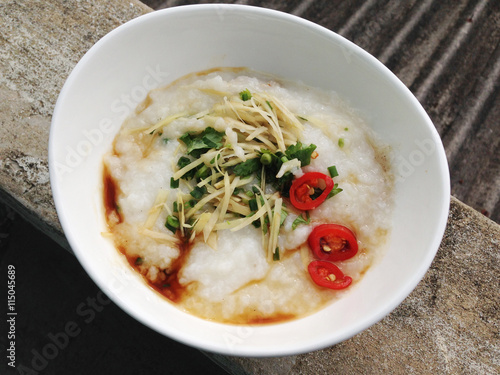 asian food - a bowl of congee with minced pork on grunge background