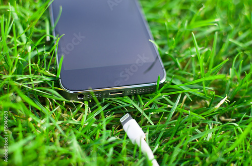 Phone detail with cable on grass