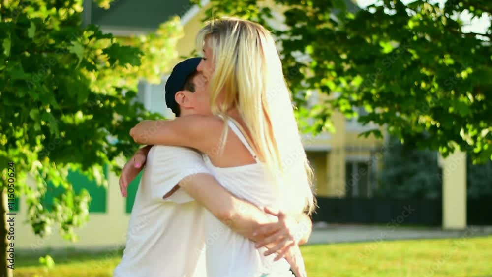 A young man hugs a woman and turns her in his arms. Slow motion
A young man hugs a woman and turns her in his arms. Slow motion