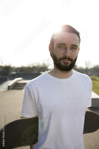 Portrait of young man holding skateboard