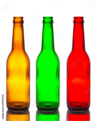 Empty bottles, brown, green and red isolated white backdrop.