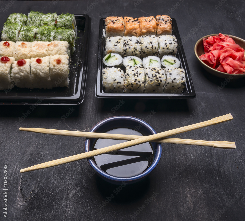 Asian food delivery home, sushi sets in plastic containers with soy sauce and chopsticks Asian food delivery home, sushi sets in plastic containers with soy sauce and chopsticks
