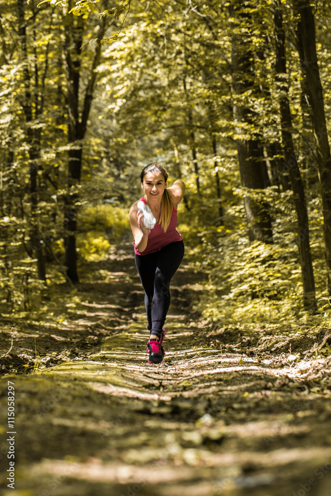 sports girl runs on a footpath in the woods