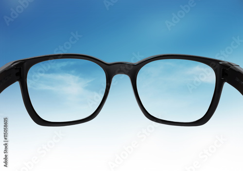 Glasses looking on blue sky, with out of focus and correct vision on lens