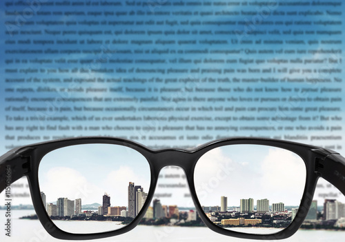 Glasses with city and sky and blurred vocabulary on sky