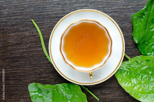 herbal plantain tea in a porcelain Cup on a dark wooden background