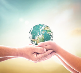 Father and son hands holding earth globe for International Father's Day and Earth Day, environmental protection, global family love and future generation concept