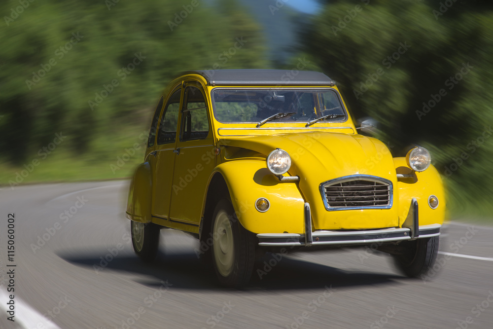 Classic yellow french car traveling in the countryside