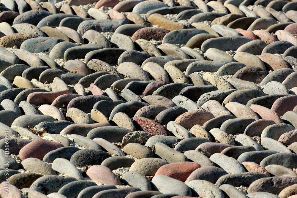 Obraz premium Pebble pavement pattern closeup. Stone mosaic background. Focus in the middle