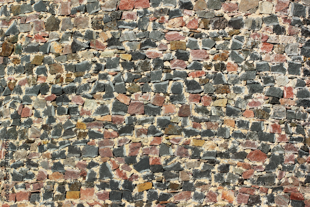 Old stone fortress wall mosaic background. Granite rock boulders