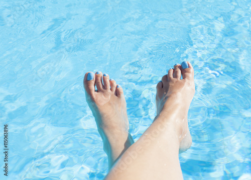 Feet of a woman on the swimming pool