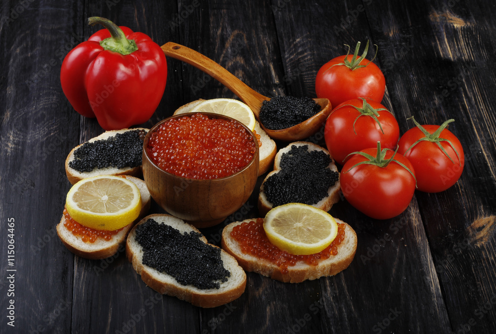 red and black caviar with bread and vegetables on wooden background red and black caviar with bread and vegetables on wooden background