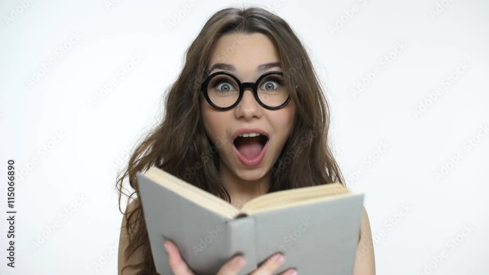 Beautiful young girl in nerd glasses reading a book Beautiful young girl in nerd glasses reading a book