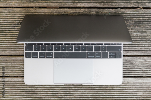 Laptop halbaufgeklappt oben auf Holztisch