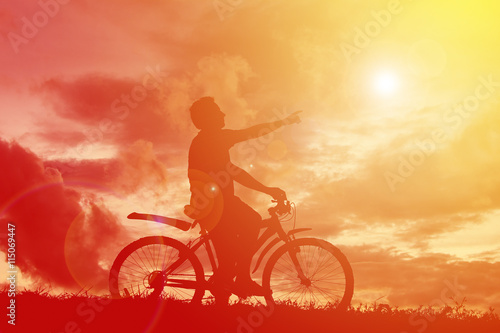 Silhouette man with bicycle at sunset. relax time