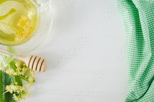 Cup of herbal tea with fresh branch linden blossom on a white wooden background. © LunaLu