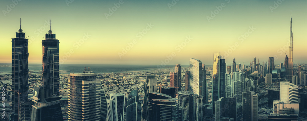 Scenic panoramic view of Dubai modern architecture at sunset. Aerial skyline with downtown skyscrapers.