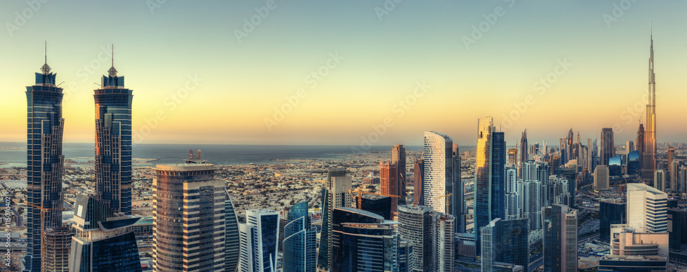 Naklejka premium Malowniczy widok na nowoczesną architekturę Dubaju o zachodzie słońca. Aerial skyline z wieżowcami w centrum miasta.