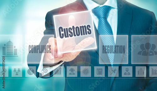 A businessman selecting a Customs Concept button on a clear screen. photo