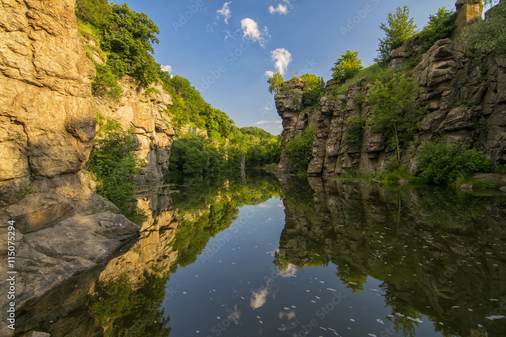 Picturesque rocks reflected in water in river canyon