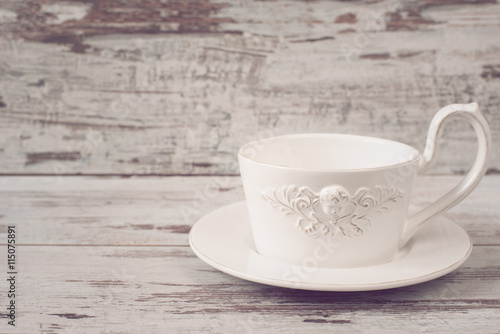 Simple rustic white crockery, empty dishes. A large cup of coffee in front angel. Wooden background, shabby chic, vintage tinting, copy space
