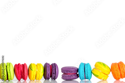 Row of Colorful macarons on white background.