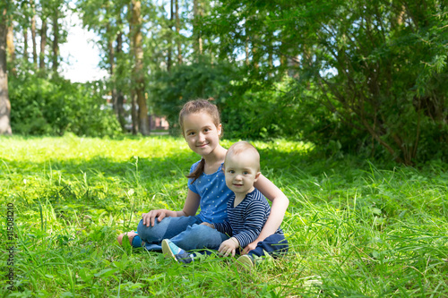 adorable baby boy and girl playing in summer park