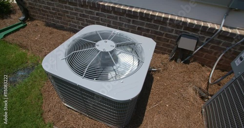 Two Central Air Conditioning Units from Above. camera starts on one air conditioning unit and rises to reveal another unit on the right side. Shot from above looking down on the units.
