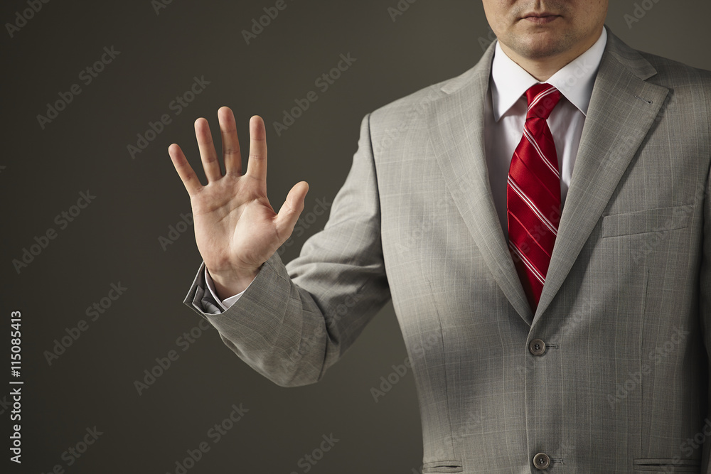 Businessman in a gray suit, white shirt and red tie on a gray background  shows an empty hand Stock Photo | Adobe Stock